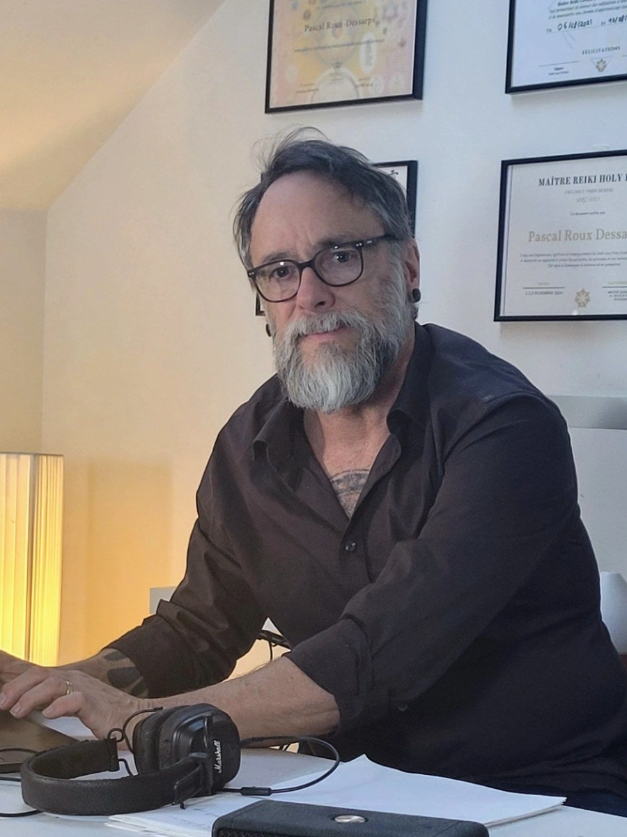 Pascal Roux-Dessarps devant ses certifications de maître enseignant Reiki